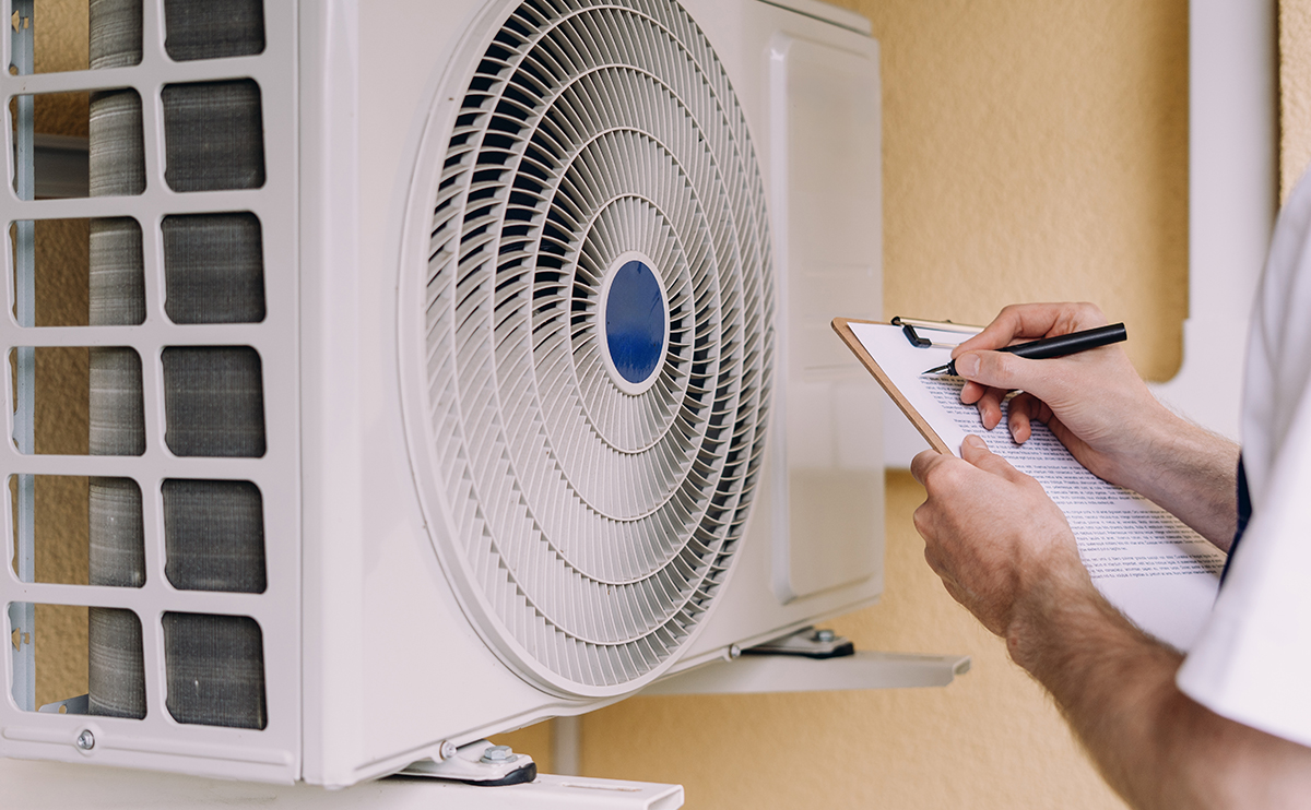 Technician examines air conditioning system